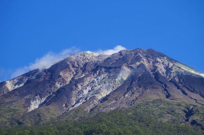 Scenic view of mountain range against blue sky