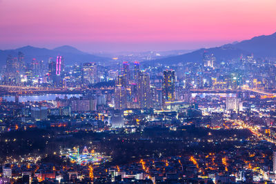 High angle view of illuminated buildings against sky at night