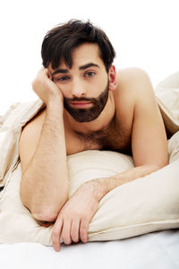 Portrait of young man lying on bed at home