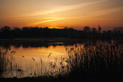 Scenic view of lake against romantic sky at sunset