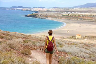 Rear view of woman standing on shore