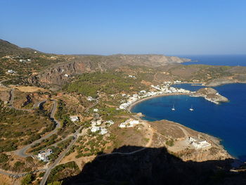 High angle view of sea and mountains against clear blue sky