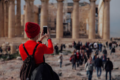 Rear view of person photographing with mobile phone