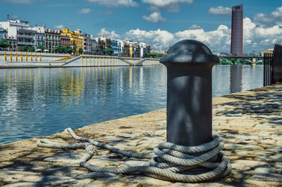 Bollard with a mooring rope without boat during coronavirus pandemic in seville.