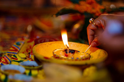 Midsection of person holding burning candle