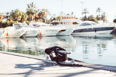 Close-up of rope tied to bollard on pier