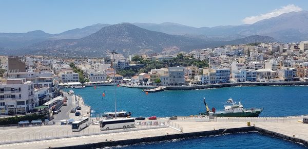 Scenic view of sea by buildings in city against sky