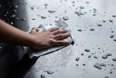 High angle view of person hand on wet floor