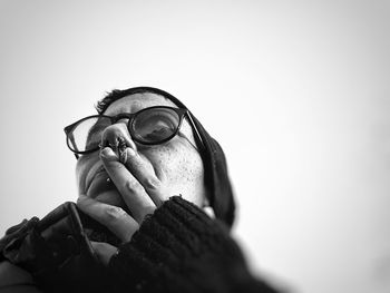 Close-up of woman smoking cigarette against clear sky