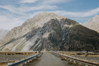 Road amidst snowcapped mountains against sky