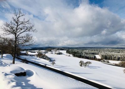 Snow covered landscape against sky