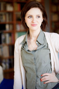 Young redhead woman standing in library