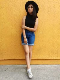 Portrait of young woman leaning against wall