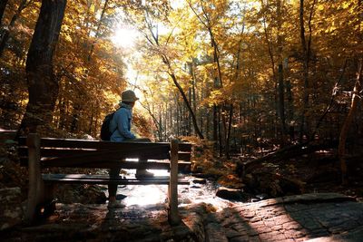 Man sitting on bench in forest