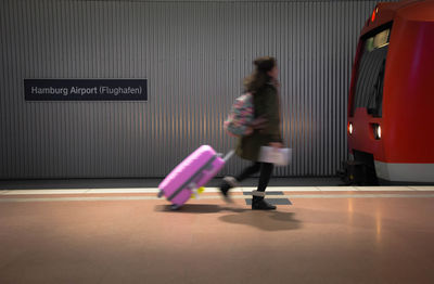 Woman walking at airport with suitcase