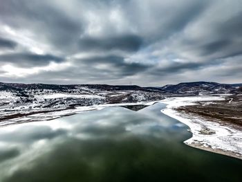 Scenic view of lake against sky during winter