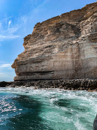 Rock formations in sea against sky