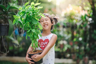 Portrait of smiling girl holding plant