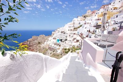 Buildings by sea against sky on sunny day