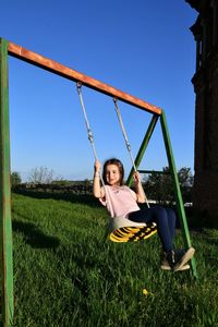 Girl playing on swing in playground