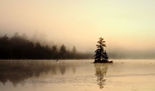 Scenic view of lake against sky during foggy weather