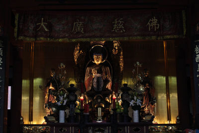 View of statue against illuminated temple