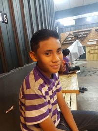 Portrait of boy sitting in corridor