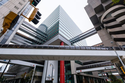 Low angle view of elevated walkway against modern buildings in city