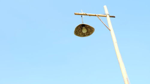 Low angle view of cross on pole against clear sky