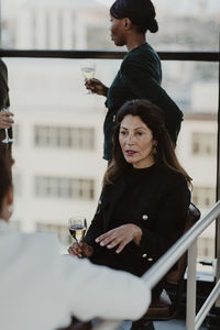 Businesswoman discussing with female colleague in office party