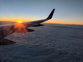 Airplane flying in sky during sunset