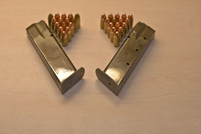 Close-up of bullets and ammunition magazines on table