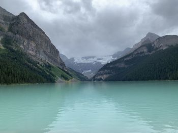 Scenic view of lake by mountains against sky