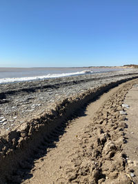 Scenic view of beach against clear blue sky