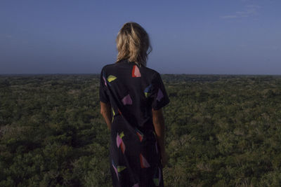 Rear view of woman standing on land