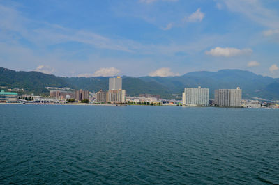 Scenic view of sea by city against sky