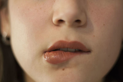 Close-up of young woman biting lips