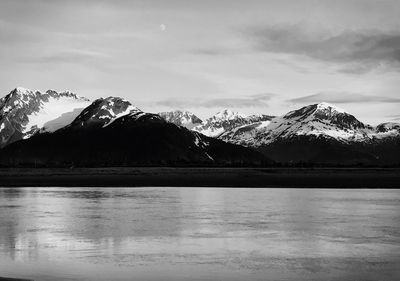 Scenic view of lake and snowcapped mountains against sky