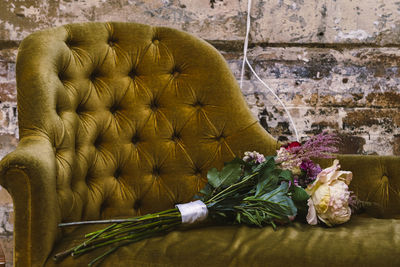 Close-up of flower vase on table against wall