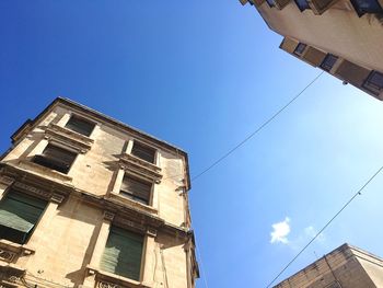 Low angle view of skyscraper against blue sky