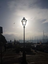 Street lights in city against sky