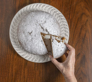 High angle view of hand holding bread on table