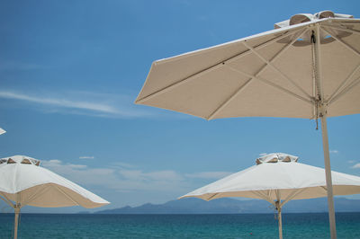 Umbrellas on beach by sea against sky
