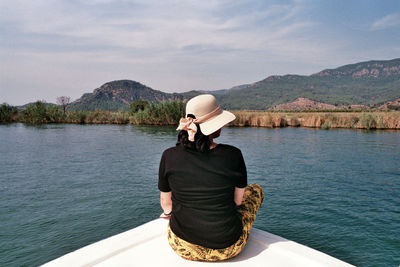 Rear view of woman in hat against mountains