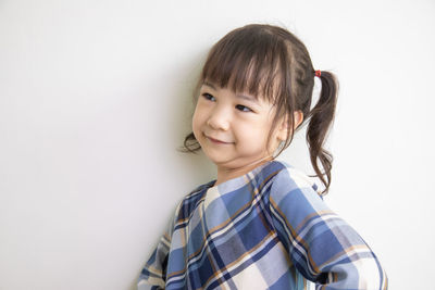 Smiling girl looking away against white background