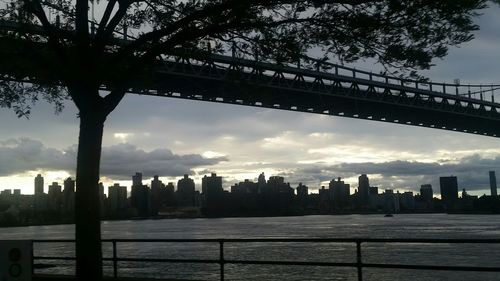 Bridge over river against cloudy sky