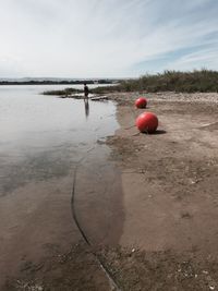 Red umbrella on beach against sky