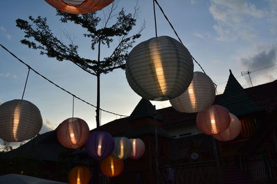 Low angle view of illuminated lanterns hanging against sky