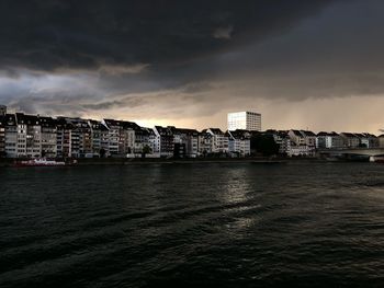 Sea by buildings against sky in city