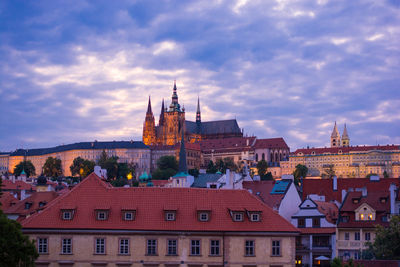 Hradcany castle in city against cloudy sky during sunset